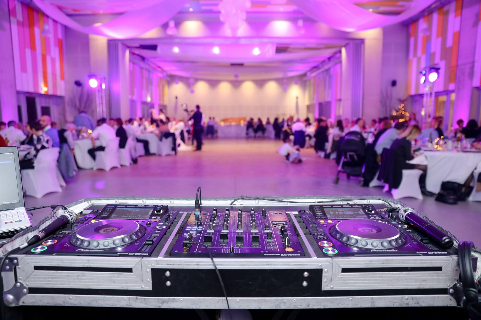 A professional DJ setup overlooking a wedding reception