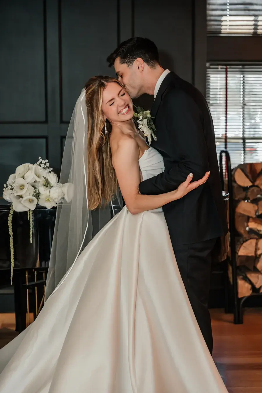 A bride and groom sharing a kiss indoors, photographed by Stephanie Vaccaro